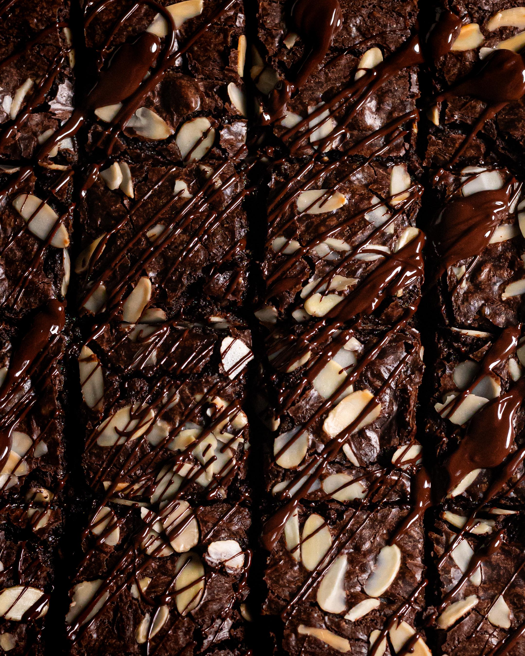 an overhead shot of a 16 piece cherry and almond brownie, topped with melted dark chocolate and flaked almonds 