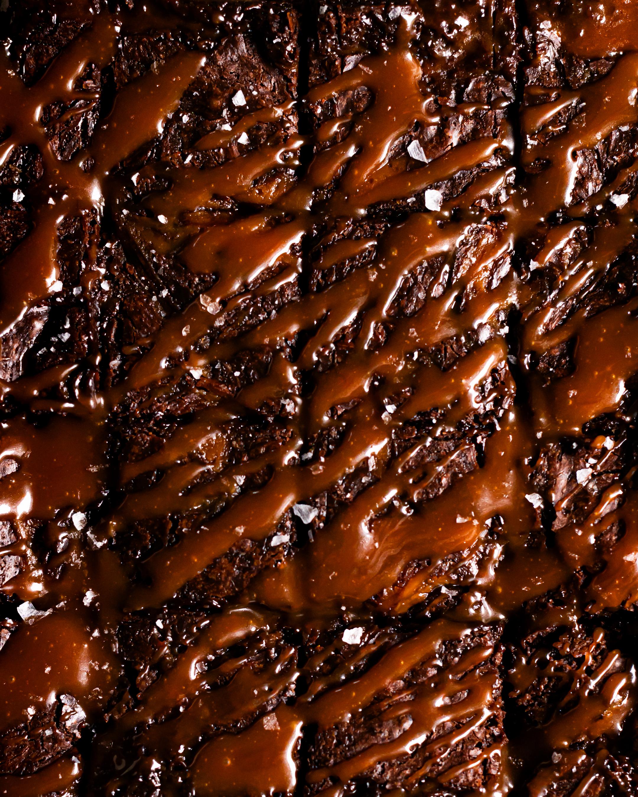 an overhead shot of salted caramel brownies cut into 16 pieces with salted caramel lathered on top sprinkled with sea salt